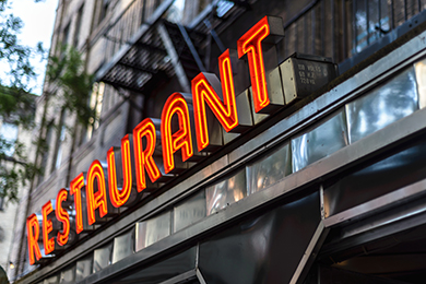 Vintage art deco neon restaurant sign on a city street storefront
